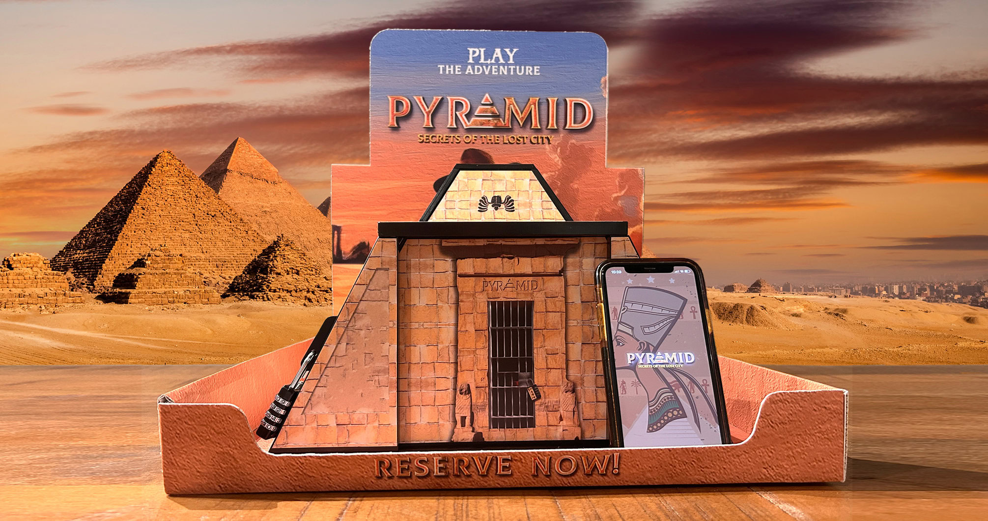 Pyramid Escape Box display at EuroParcs, featuring a physical pyramid puzzle, a lock mechanism, and the Pyramid XR app on a smartphone.