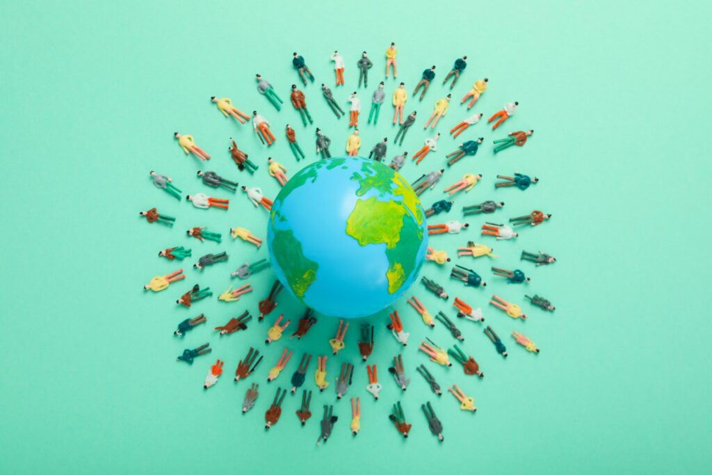 Illustration of a globe surrounded by people from different locations, representing employees and teams participating in a multi-city corporate competition connected through a shared global event experience.
